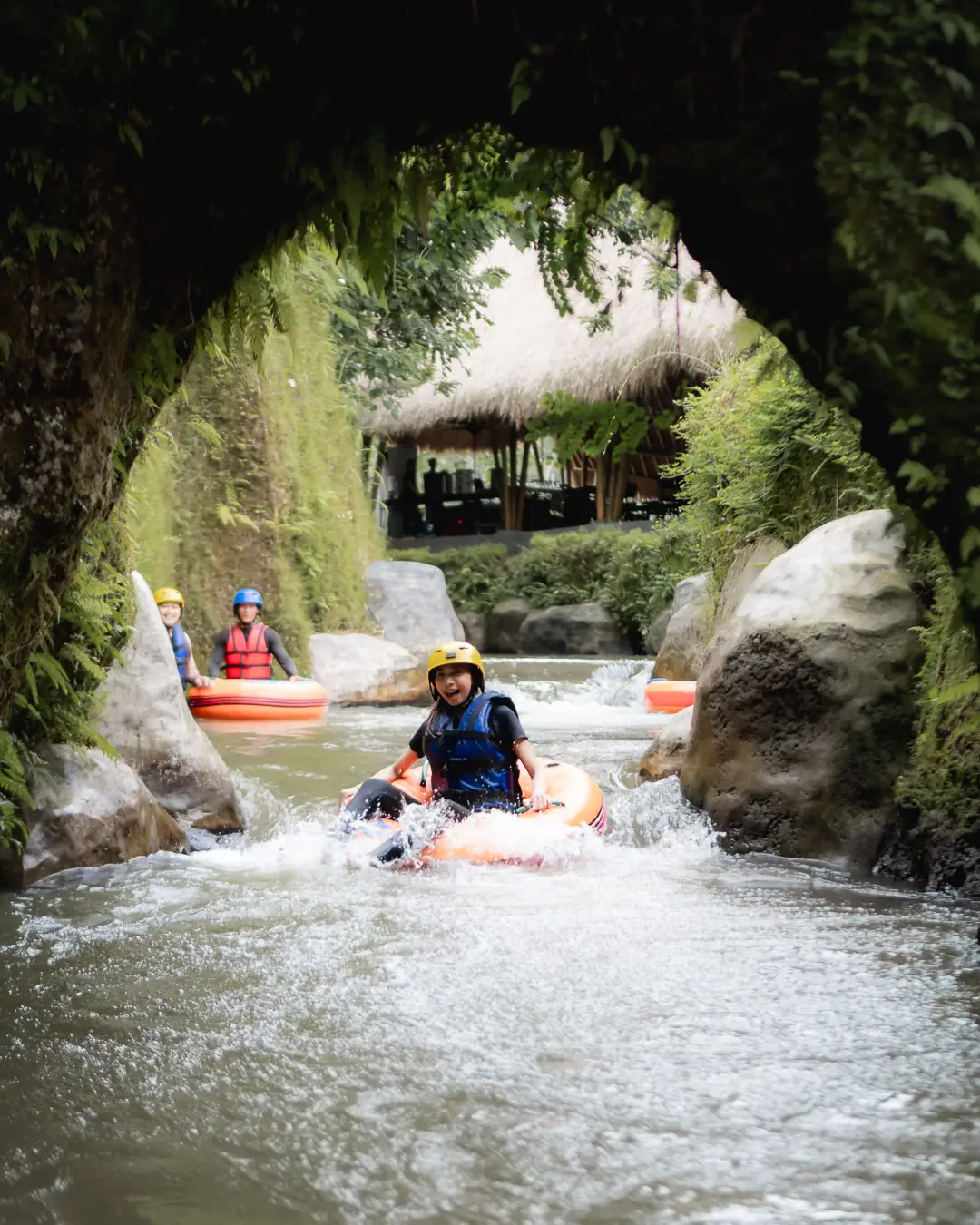 Cave tubing adventure through rock tunnel with river rafting boats in Tegalalang